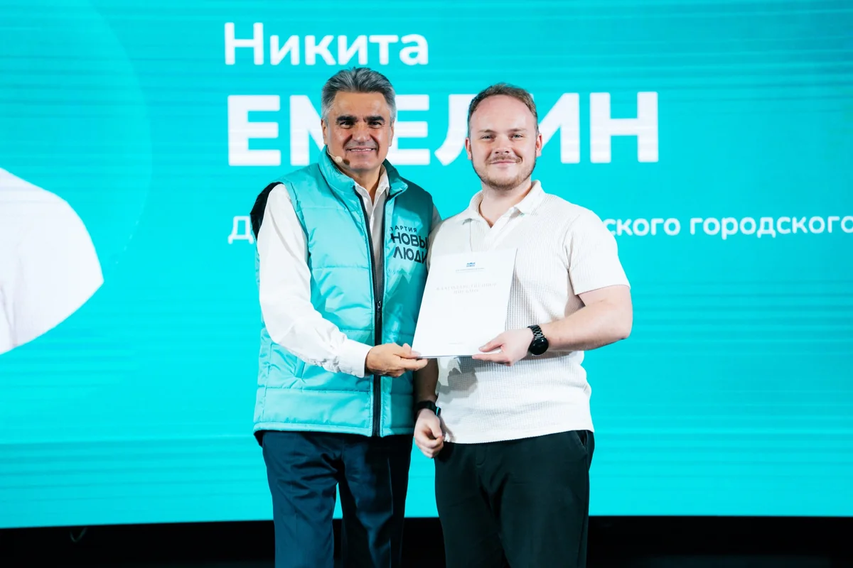 Никита Емелин получает документ по итогам общественного мероприятия